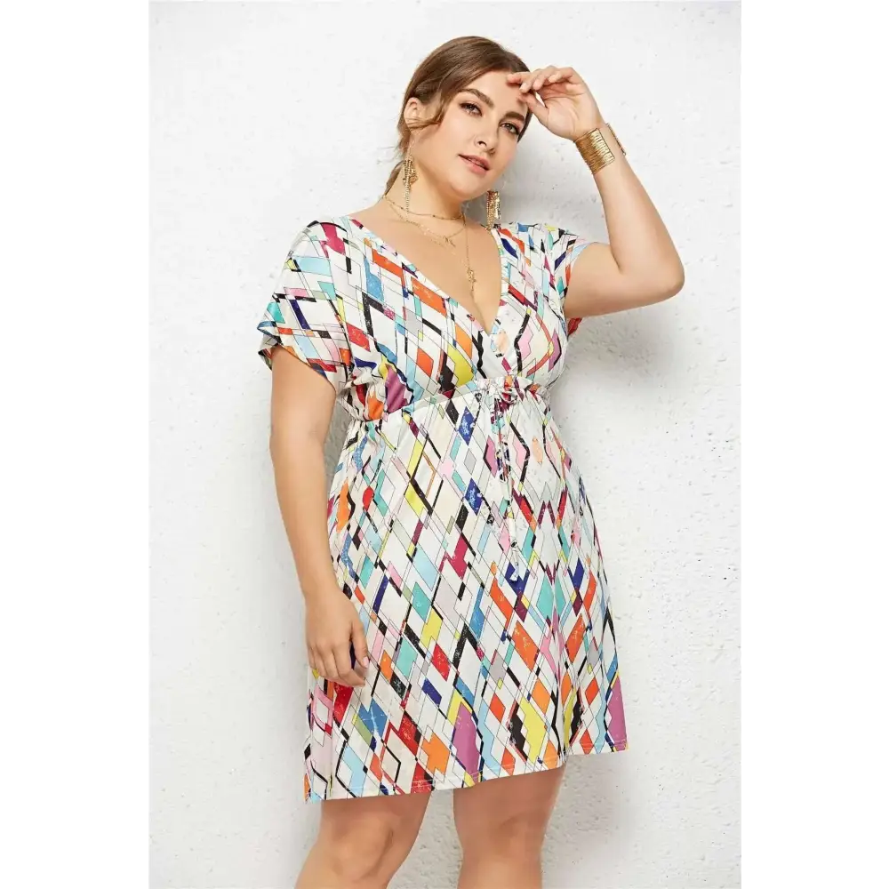 A vibrant geometric printed deep v-neck plus-size dress with short sleeves and elastic waist in multicolor on white fabric