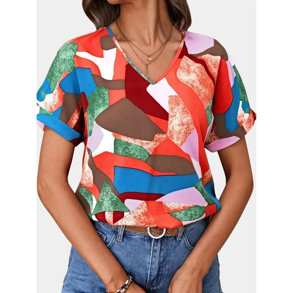 Vibrant geometric-patterned women’s clothing printed v-neck top in red blue green and brown tones with short sleeves
