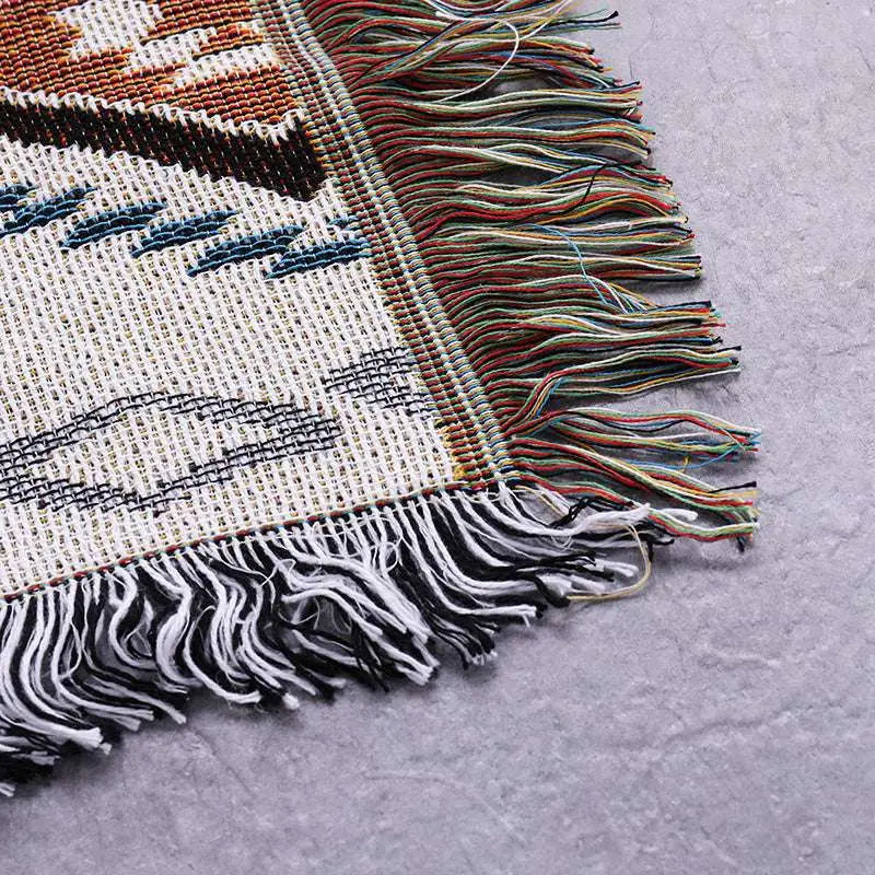 Geometric woven fringed sofa blanket in earthy tones with black patterns and multicolored fringes for sofa use