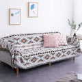 Geometric woven fringed sofa blanket in gray with black and rust accents featuring fringe detailing for sofa use