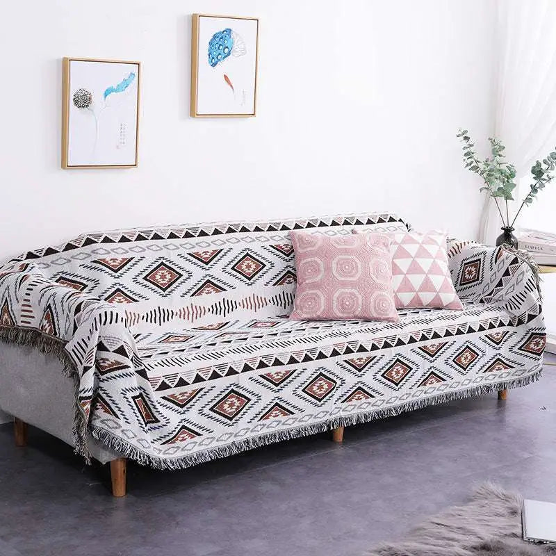 Geometric woven fringed sofa blanket in gray with black and rust accents featuring fringe detailing for sofa use