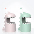 Pastel pink and mint green dinosaur mosquito lamp with smooth plastic bodies and open mouths as mosquito storage box