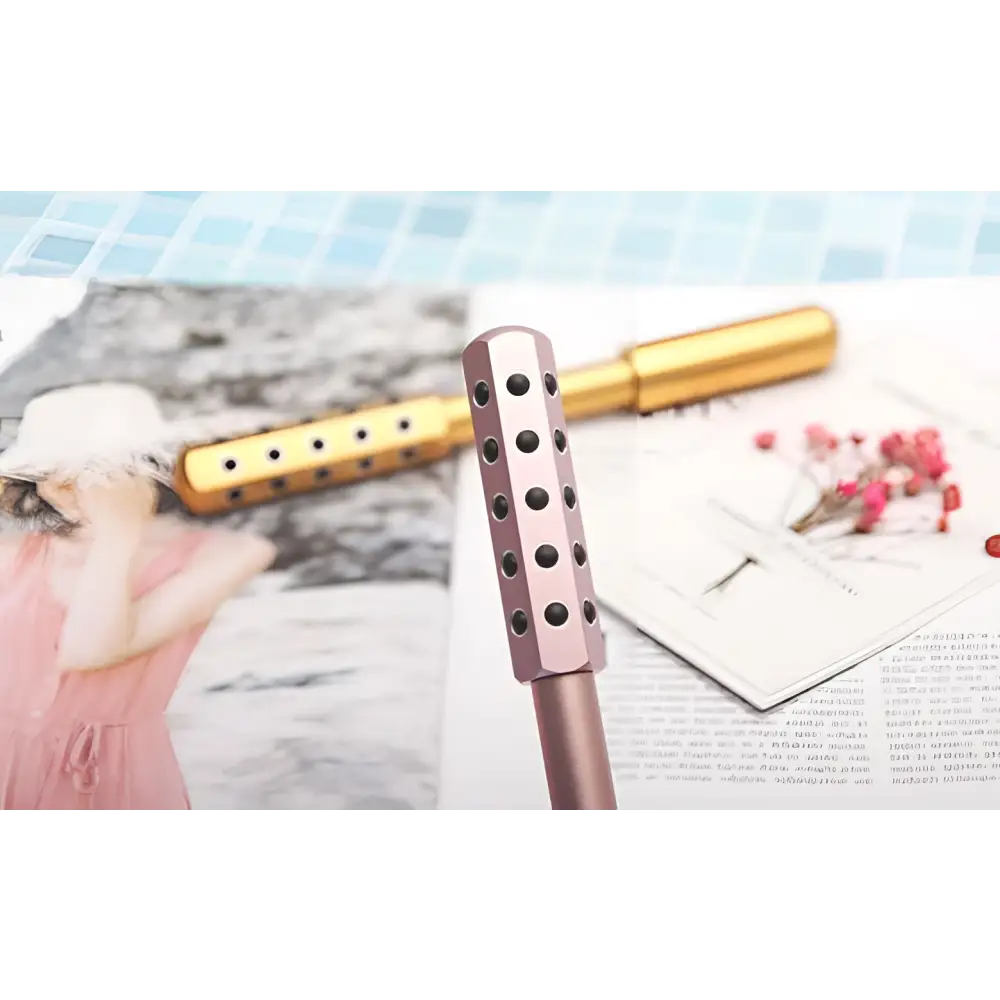 Rose gold germanium beauty roller with hexagonal head and black indentations for facial massage roller massage stick