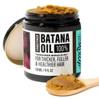 Glow restore hair mask batana oil treatment in a black jar with golden brown unrefined batana oil on spoons