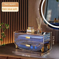 A sleek transparent acrylic cosmetics storage box with gold acrylic drawer pulls and klein blue striped design makeup organizer