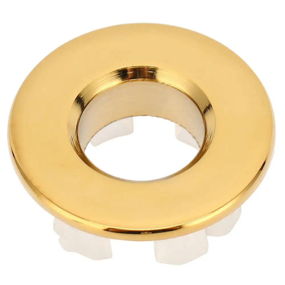 Gold bathroom wash basin sink hole overflow cover with polished metallic finish and white plastic mounting flanges