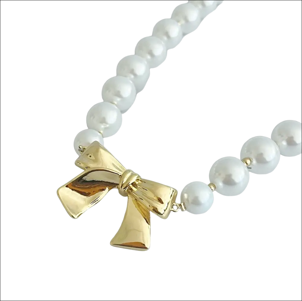 A pearls necklace with lustrous white pearls and a gold bow pendant perfect for luxury women’s fashion