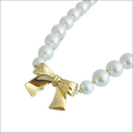 A pearls necklace with lustrous white pearls and a gold bow pendant perfect for luxury women’s fashion