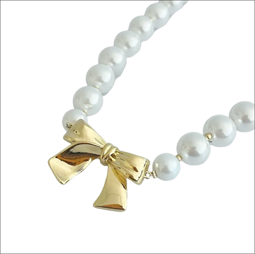 A pearls necklace with lustrous white pearls and a gold bow pendant perfect for luxury women’s fashion