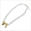 A delicate pearls necklace with lustrous white pearls and a gold bow pendant for luxury women’s fashion
