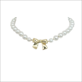 A delicate white pearls necklace with a shiny gold bow pendant for luxury women’s fashion and plus size dresses bikinis