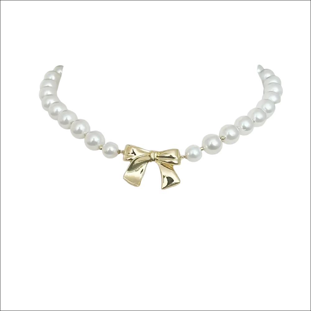 A delicate white pearls necklace with a shiny gold bow pendant for luxury women’s fashion and plus size dresses bikinis