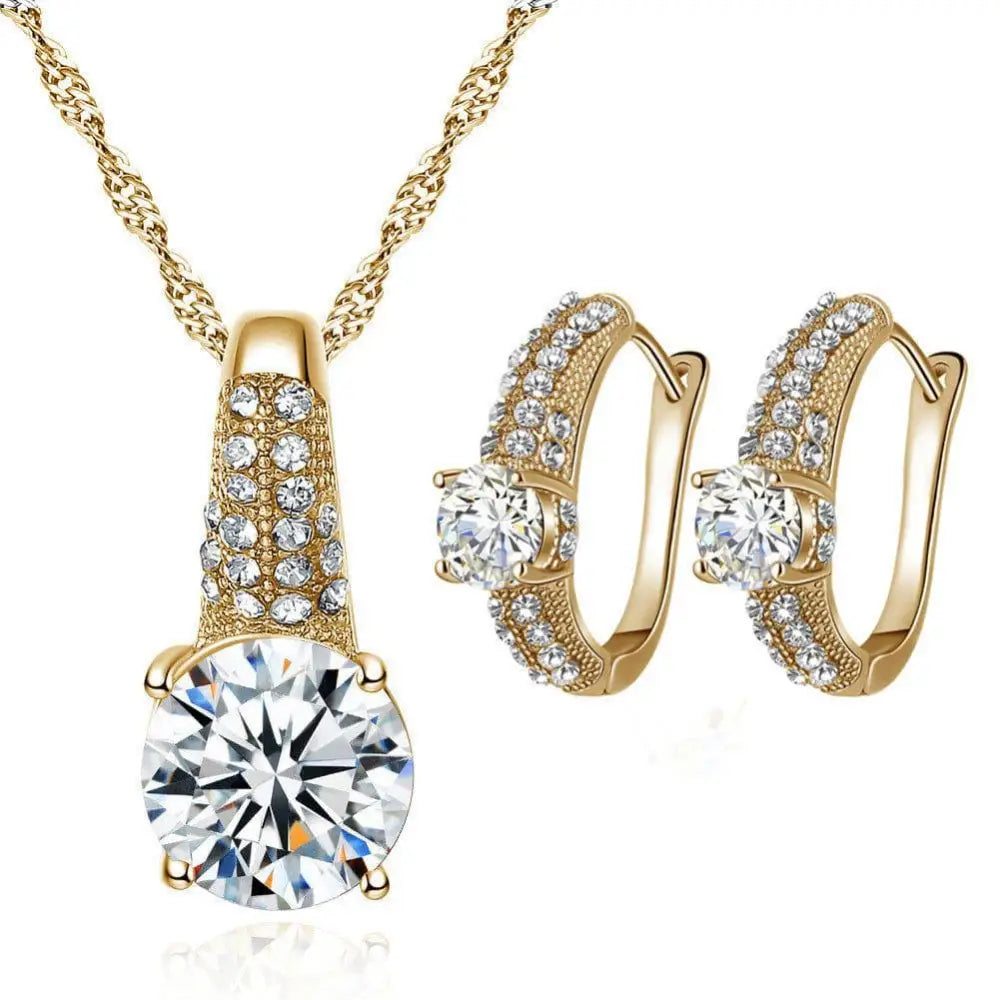 Gold bridal necklace and earrings jewelry set featuring gold tone and round cut clear gemstone studs for brides