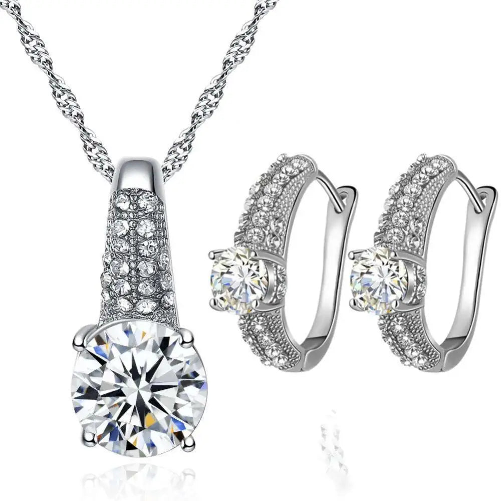 Silver-toned bridal necklace and earrings set with round-cut clear gemstone and intricate pave settings for gold bridal look