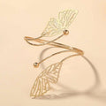 Gold butterfly arm cuff with intricate cut-out gold-toned butterfly wing design and small spherical accents