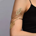 Gold butterfly arm cuff featuring intricate cut-out gold-toned butterfly wing design with delicate chain detail