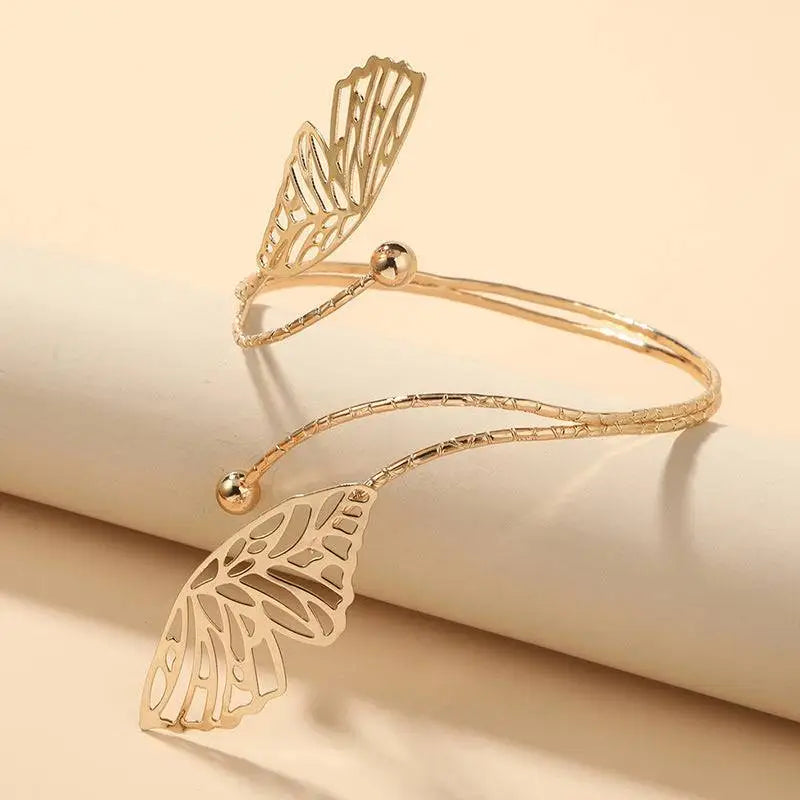 Gold-toned butterfly wing cuff bracelet with intricate cut-out detailing and textured band as a butterfly arm cuff accessory