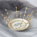 A delicate gold crystal bride handmade star crown with clear crystal flowers on a white ceramic dish