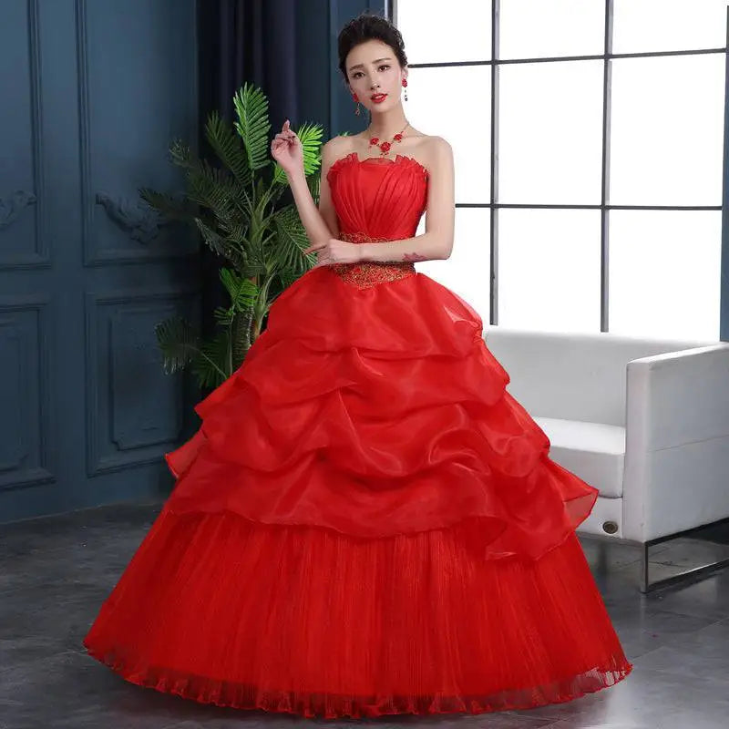 A large size red wedding dress featuring layered tulle, satin ruffles, and gold embroidered detailing at the waist
