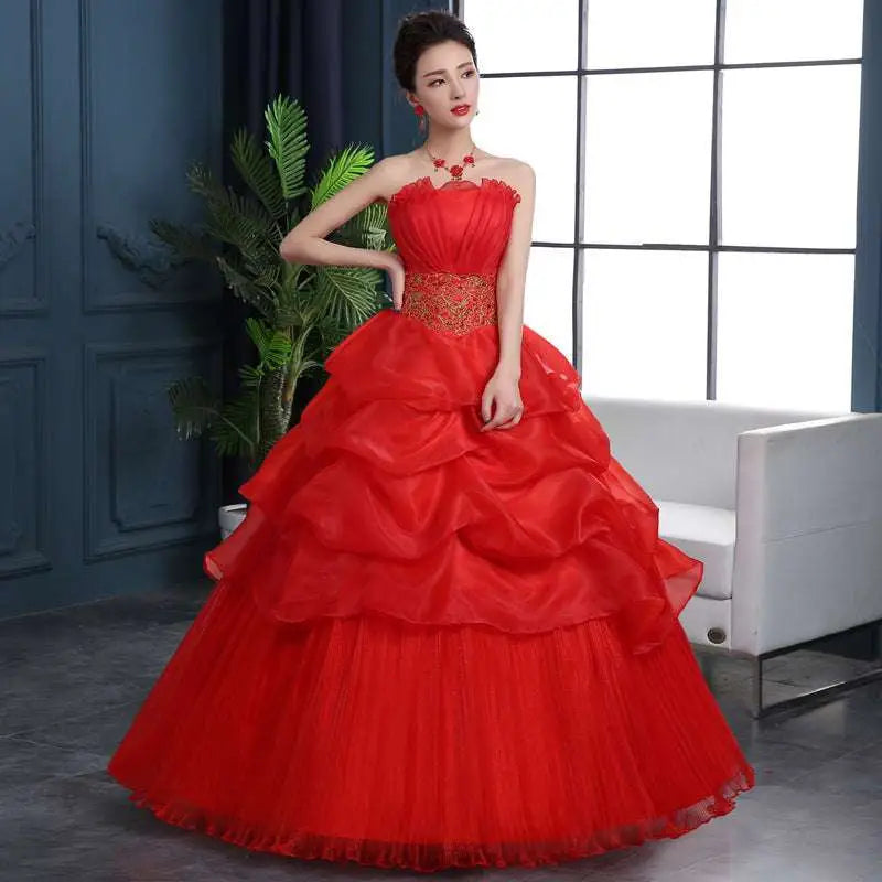 A vibrant large size red wedding dress with gold embroidered fitted bodice and tiered sheer tulle skirt