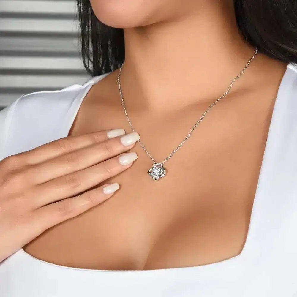 Gold floral knot daughter’s love necklace with a gold-toned pendant featuring a clear central stone in an ornate design
