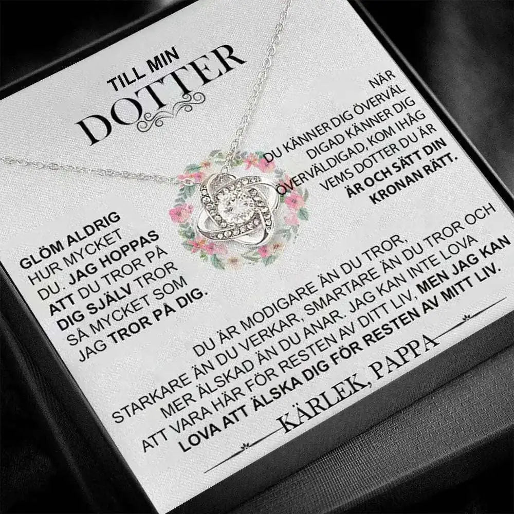 Silver infinity knot pendant necklace with clear central and smaller stones displayed on a gold floral knot daughter’s love necklace gift card