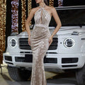 A gold floral velvet halter banquet evening dress with intricate floral pattern and shimmering champagne color