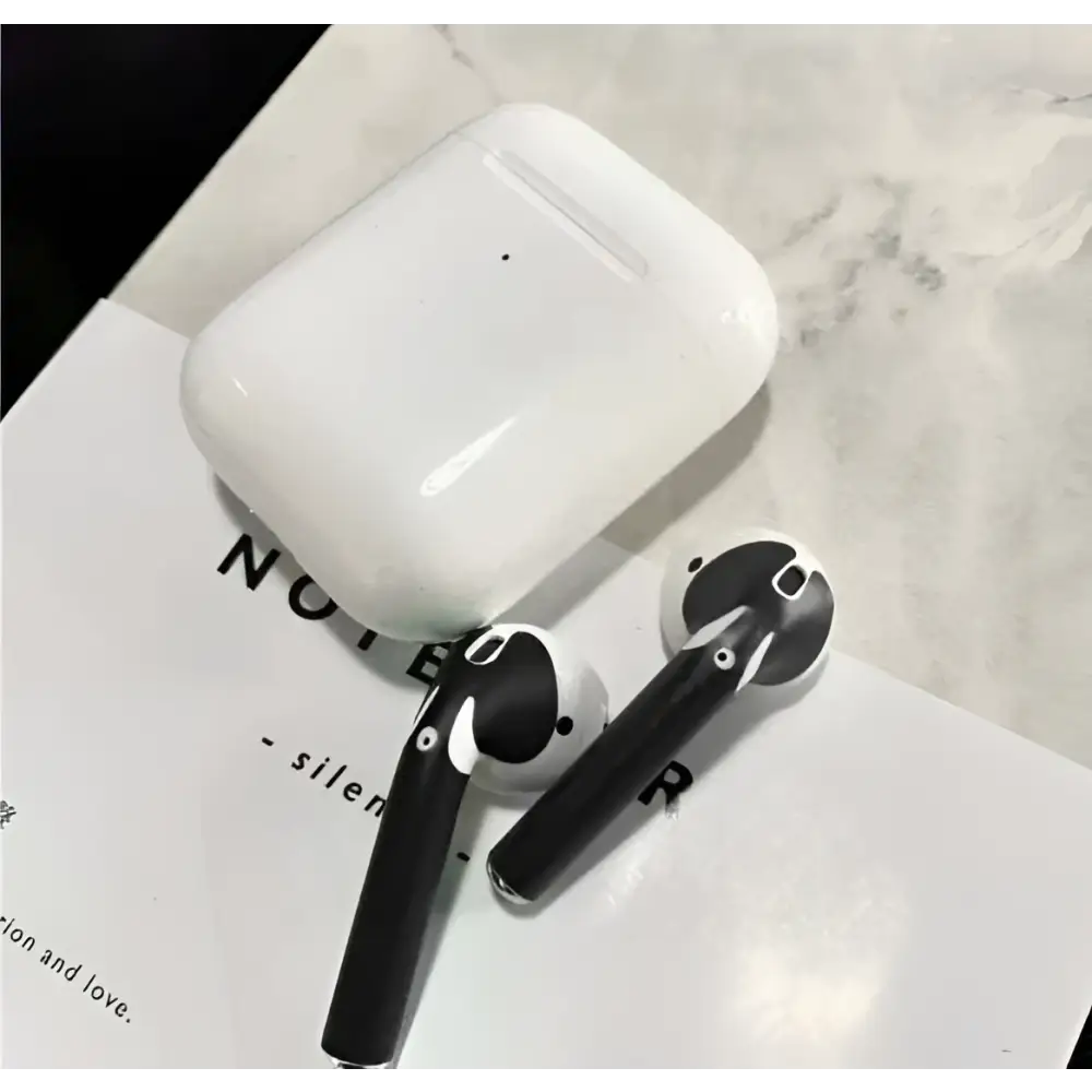 White apple airpods with black silicone ear tips and a matching charging case featuring a custom sticker skin