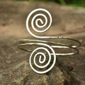 Silver spiral arm ring cuff bracelet with hammered texture and open-ended coil design in sleek minimalist style
