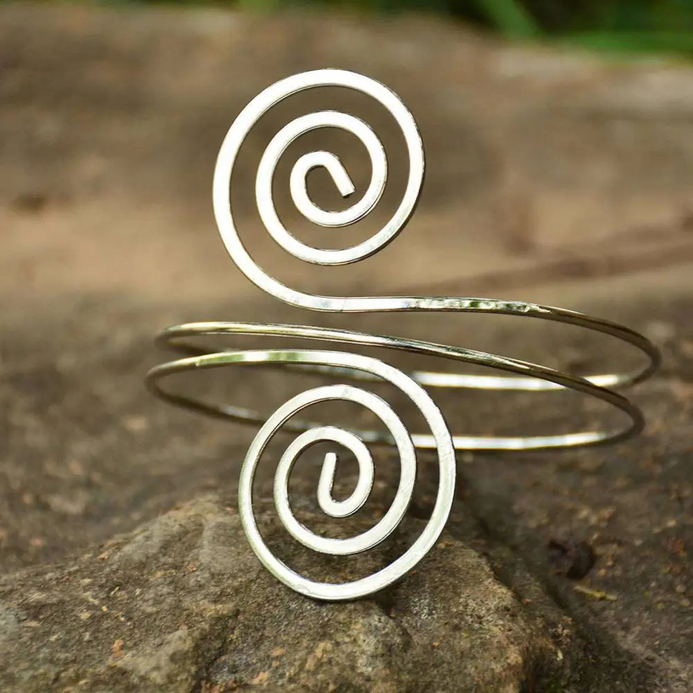 Silver spiral arm ring cuff bracelet with hammered texture and open-ended coil design in sleek minimalist style