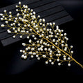 A delicate gold pearl branch outdoor hair comb with small white pearls in a leaf design for bride wedding use