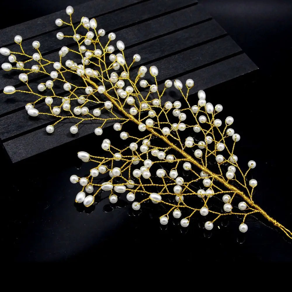 A delicate gold pearl branch outdoor hair comb with small white pearls in a leaf design for bride wedding use