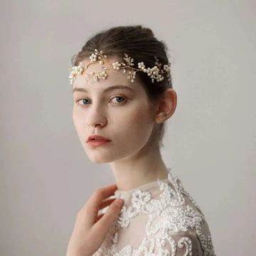 Delicate gold-toned pearl flower wedding headband featuring intricate floral wirework and tiny pearls for bridal wear