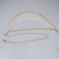 Gold-toned waist chain with three parallel strands featuring two pearl jewelry accessories and one plain metal chain