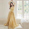 A shimmering gold satin heavy industry birthday dress with a fitted bodice and flowing skirt for industry birthday events