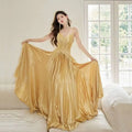A shimmering gold satin heavy industry birthday dress with a fitted bodice and flowing pleated skirt