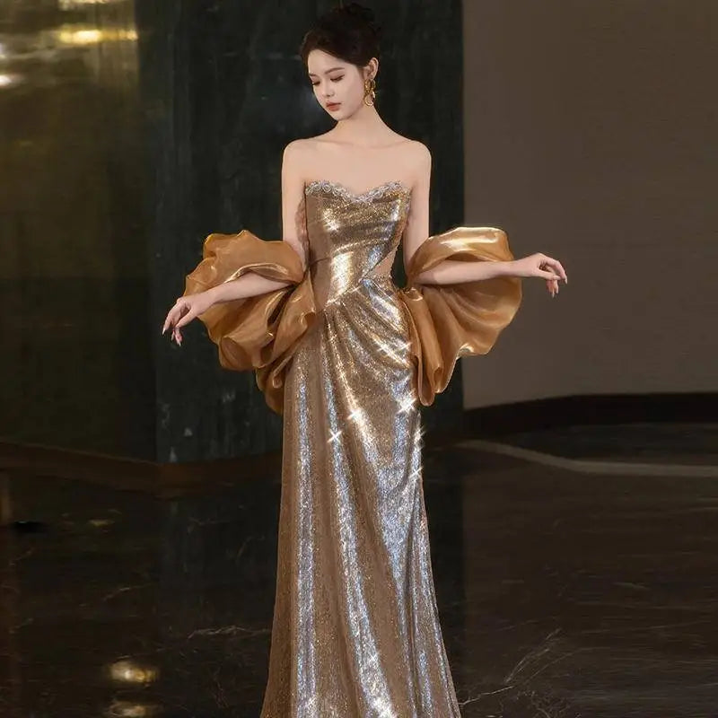 A gold sequined banquet temperament evening dress with voluminous satin sleeves and a fitted bodice