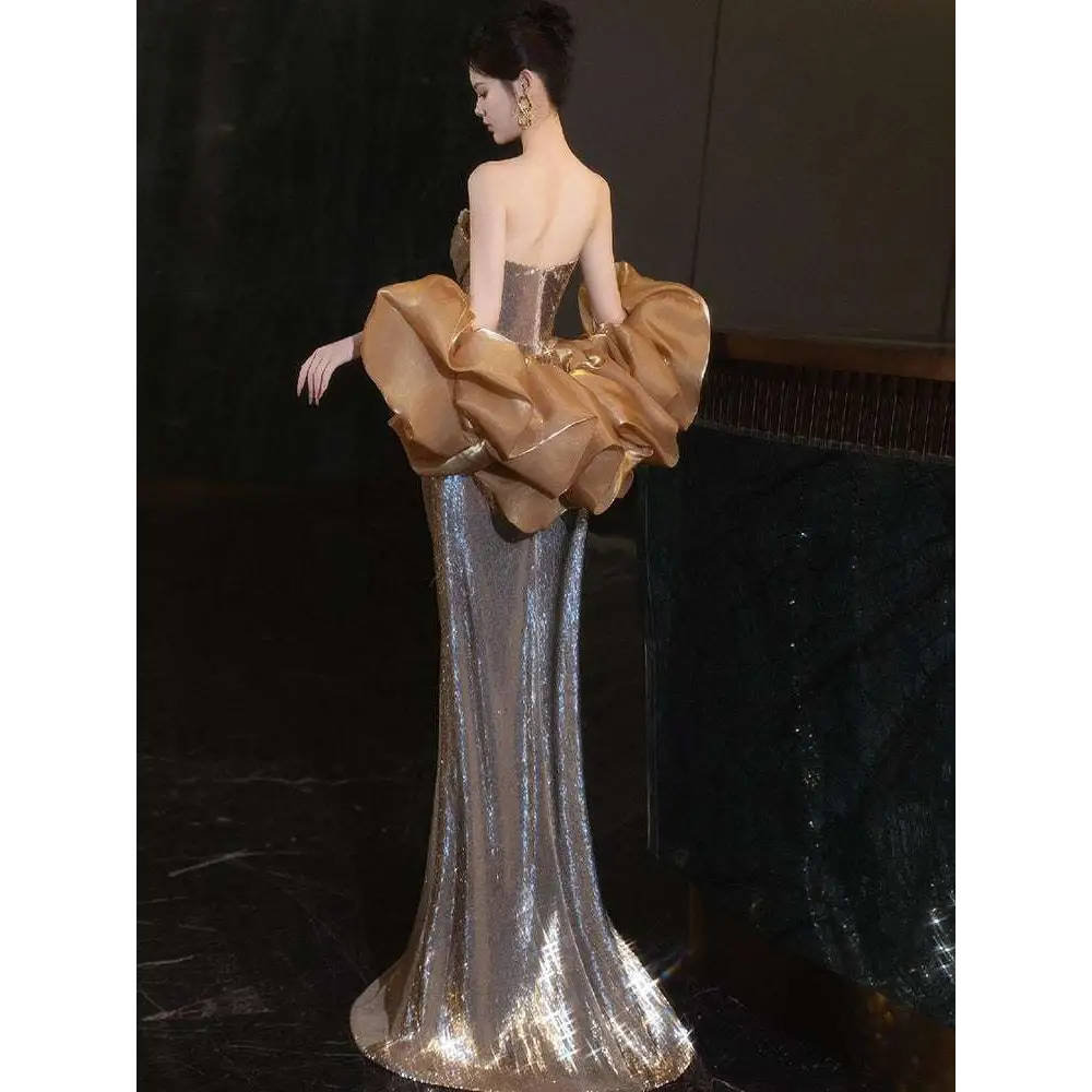 A temperament evening dress with shimmering silver sequins and dramatic gold ruffled sleeves for a gold sequined banquet