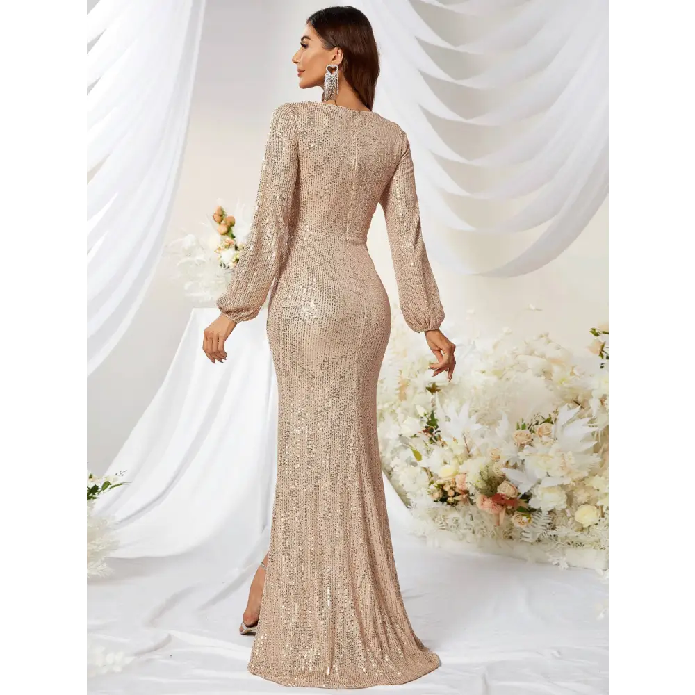 A shimmering gold sequined long sleeve evening gown with high slit fishtail design and high neckline