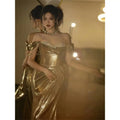 A gold sequined off-shoulder dress bridal fishtail gown with a fitted bodice and flowing skirt perfect as a toast dress bridal