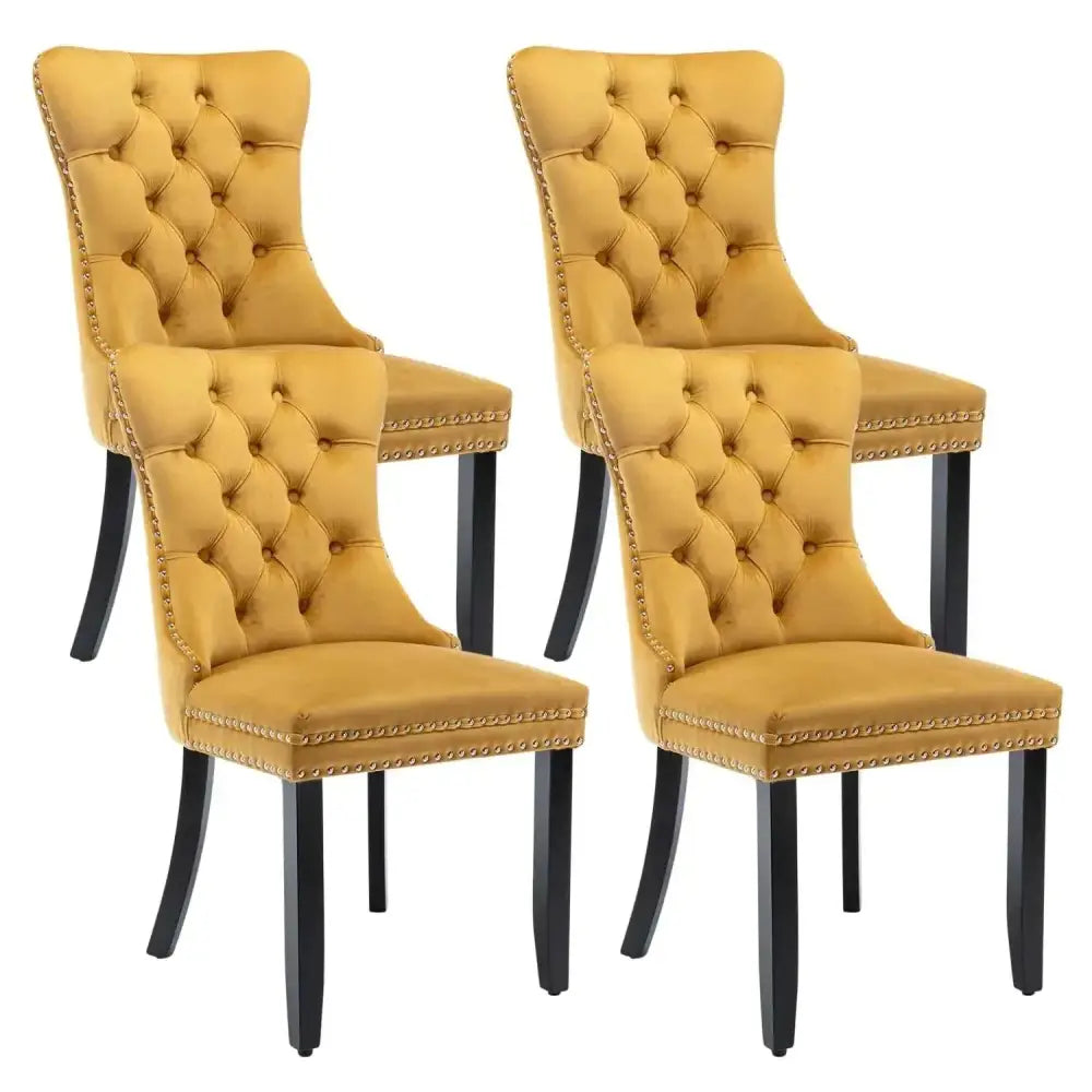 Set of four mustard-yellow gold tufted velvet dining chairs with black legs and gold nailhead trim dining chairs set