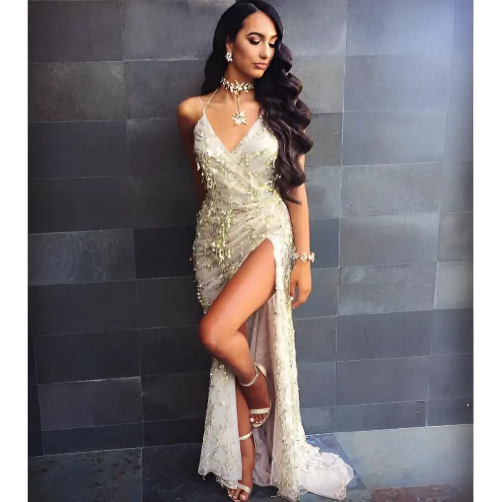 A silver strap sequin dress with a gold v neck, high slit, and delicate lace overlay for elegant occasions