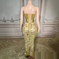 Back view of a shimmering gold surface bandage metallic mermaid gown with lace-up back and cascading triangular fringe
