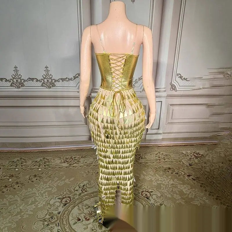 Back view of a shimmering gold surface bandage metallic mermaid gown with lace-up back and cascading triangular fringe