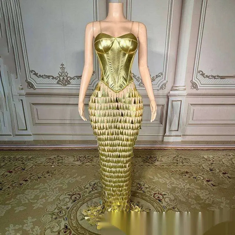 A shimmering golden bright surface bandage metallic mermaid gown with structured bodice and triangular fringe detailing