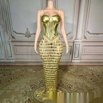 A shimmering golden bright surface bandage metallic mermaid gown with structured bodice and triangular fringe detailing