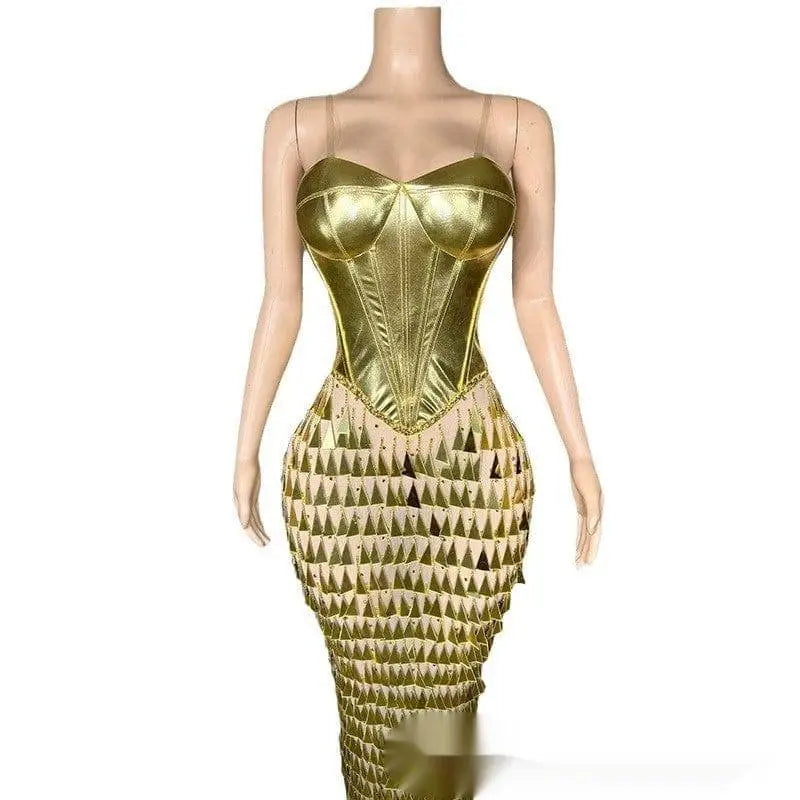 A shimmering gold metallic mermaid gown with a structured bodice and triangular cutouts in surface bandage metallic