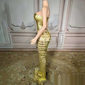 A shimmering gold metallic mermaid gown with fitted bodice and cascading triangular scales features a golden bright surface bandage design