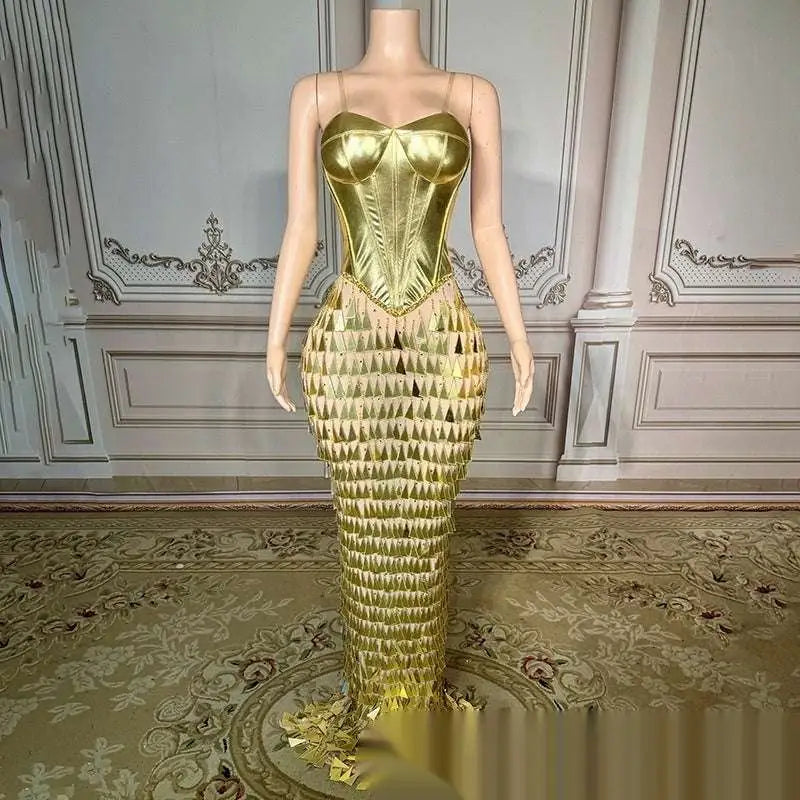 A shimmering gold metallic mermaid gown with a structured corset top and cascading golden bright surface bandage scales