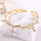 Golden crown headband wedding headdress adorned with clear crystals and teardrop pendants for elegant occasions